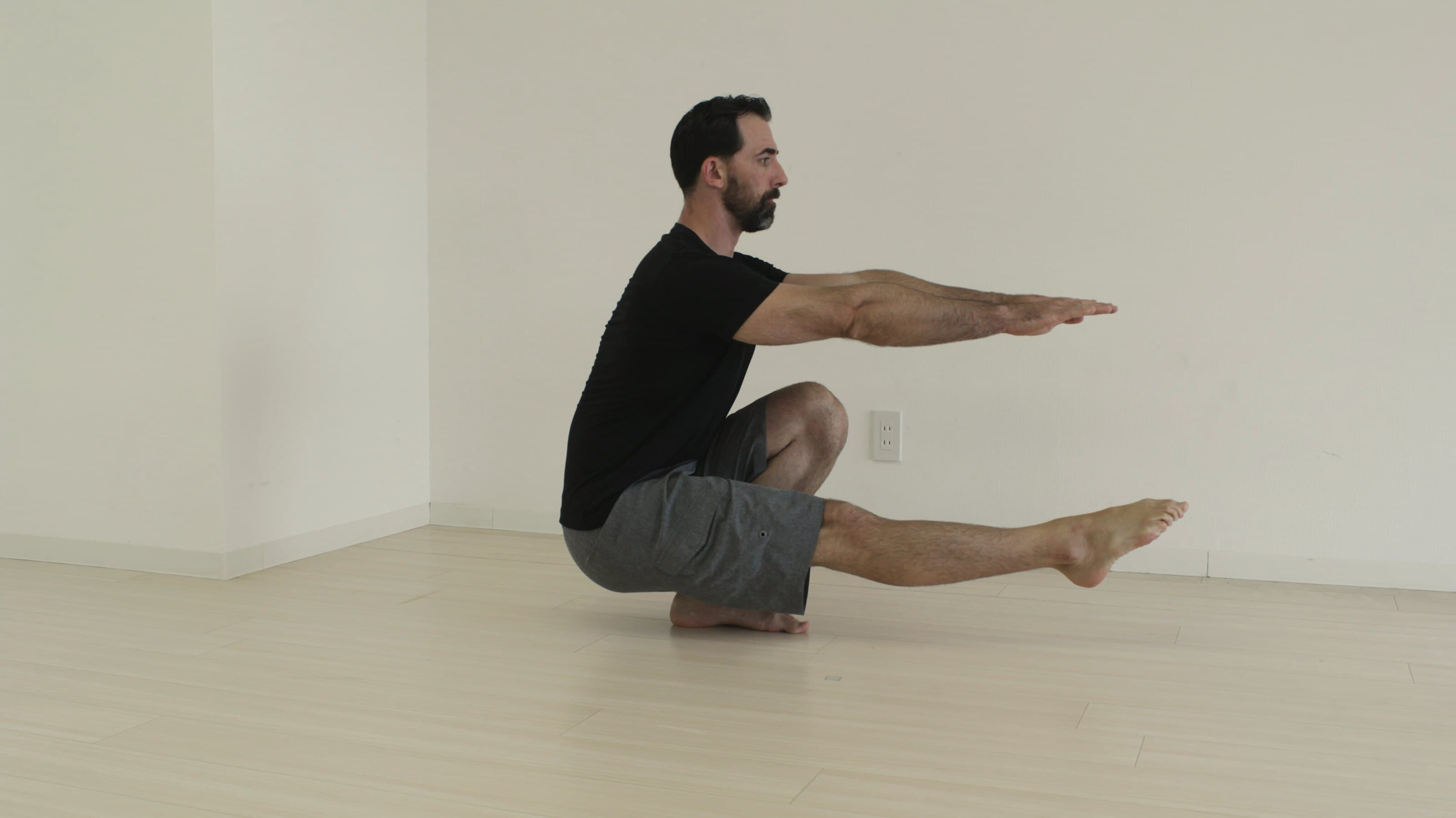 Mand holder balancen i en dyb pilates-øvelse