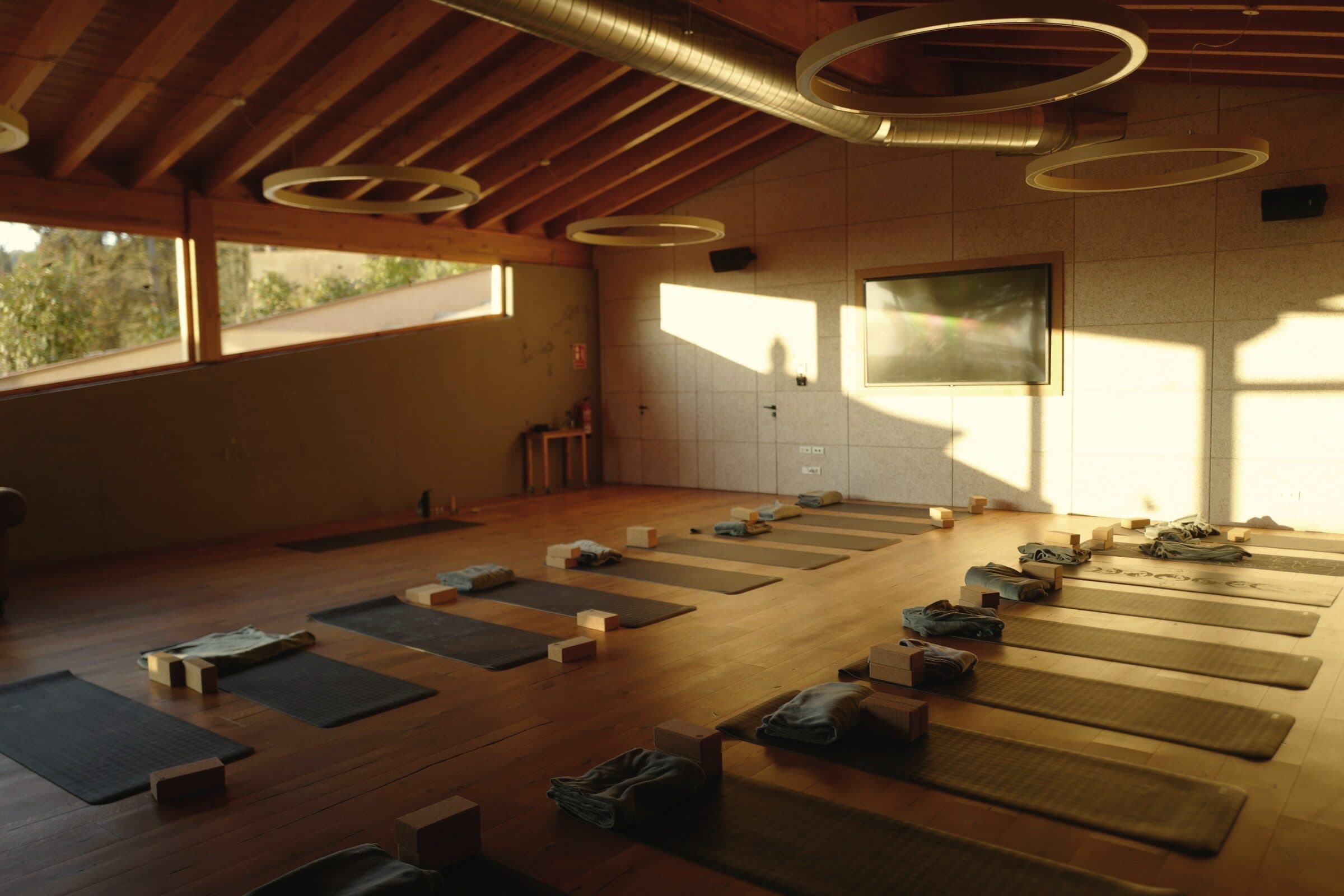 Tomt træstudie med yogamåtter i aftenlys